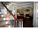 Open-concept living room with a fireplace, hardwood floors, and access to other areas of the home at 408 Greenfern Ct, Burlington, NC 27215