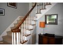 Carpeted staircase featuring a classic wooden handrail and painted white risers at 408 Greenfern Ct, Burlington, NC 27215
