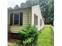 Home exterior featuring light siding, brown shutters, and a view of the yard at 4112 Forrest Ave, Efland, NC 27243