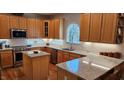 Well-lit kitchen featuring custom cabinets, granite countertops, and stainless steel appliances at 4305 Heathgate Ln, Raleigh, NC 27613