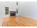 Bright and airy living room featuring hardwood floors, a stone fireplace, and ample natural light at 4305 Heathgate Ln, Raleigh, NC 27613