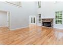 Spacious living room with a fireplace, hardwood floors, and lots of natural light from the windows at 4305 Heathgate Ln, Raleigh, NC 27613