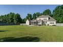 Large backyard featuring a well-maintained lawn, patio, and a screened-in porch at 5305 Yorkville Ct, Holly Springs, NC 27540