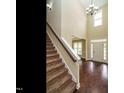 The foyer features soaring ceilings, hardwood floors, and staircase at 5400 Falconton Ln, Raleigh, NC 27610
