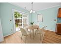 Bright dining area featuring a sliding glass door and stylish furniture with backyard views at 5561 Roan Mountain Pl, Raleigh, NC 27613
