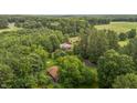 High angle shot from above of the property's main home surrounded by mature trees with a second home nearby at 5918 Efland Cedar Grove Rd, Cedar Grove, NC 27231