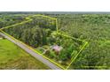 Expansive aerial view showcasing the property's generous lot size surrounded by lush trees and bordered by a road at 5918 Efland Cedar Grove Rd, Cedar Grove, NC 27231