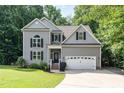 Charming two-story home features a gray siding, well-maintained lawn, and an attached two-car garage at 6717 Country Hollows Ln, Holly Springs, NC 27540