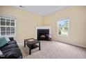 Cozy living room featuring a fireplace, plush carpet, and ample natural light from the windows at 702 Calavaras Ln, Knightdale, NC 27545