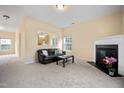 Open-concept living room with a fireplace, plush seating, and a view into the adjoining kitchen area at 702 Calavaras Ln, Knightdale, NC 27545