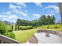 Spacious backyard with a stone-paved patio and a built-in fire pit, enclosed by a black metal fence at 710 Legacy Falls S Dr, Chapel Hill, NC 27517