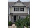 Charming townhouse exterior with black shutters, a welcoming front porch, and verdant landscaping at 711 Keystone Park Dr # 78, Morrisville, NC 27560