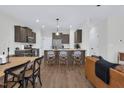 Open-concept kitchen with a large island, stainless steel appliances, and seamless flow to the living and dining areas at 717 Utley St, Holly Springs, NC 27540