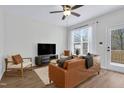 Bright living room features hardwood floors, a ceiling fan, and a sliding glass door to the outdoor deck at 717 Utley St, Holly Springs, NC 27540