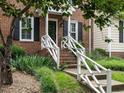 Close-up of brick home's front porch and landscaped entry with white railing at 7312 Sweet Bay Ln, Raleigh, NC 27615