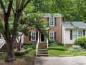 Two-story brick home with well-manicured front yard and lush trees, offering curb appeal at 7312 Sweet Bay Ln, Raleigh, NC 27615