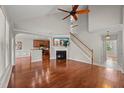 Bright living room featuring hardwood floors, fireplace, staircase, and views of the kitchen and entryway at 7873 Cape Charles Dr, Raleigh, NC 27617