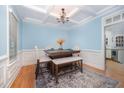 Stylish dining room with coffered ceiling, and a patterned rug under the dark table at 804 Town Side Dr, Apex, NC 27502