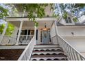 Inviting entryway with stairs leading to a covered porch with a light blue front door at 804 Town Side Dr, Apex, NC 27502