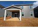 Gray home featuring a backyard patio with white columns and trim and a sliding glass door entrance at 88 Willow Cameron Way, Angier, NC 27501