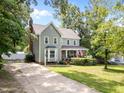 Two-story home with a charming front porch, lush lawn, and a long driveway at 8808 Colesbury Dr, Raleigh, NC 27615