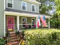 View of the home's inviting front porch and pink front door, perfect for relaxing at 8808 Colesbury Dr, Raleigh, NC 27615