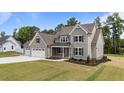 Well-manicured lawn and landscaping enhance the curb appeal of this inviting two-story home at 90 Lane Farms Way Way, Holly Springs, NC 27540