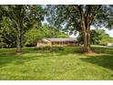 Spacious brick home nestled among mature trees, offering a serene and private setting on a sprawling lawn at 913 Milton Rd, Durham, NC 27712
