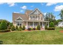 Attractive two-story home with a charming front porch, lush lawn, and professionally designed landscaping at 1001 Pasture View Ln, Raleigh, NC 27603
