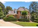 Stately brick home boasts meticulous landscaping, mature trees, and inviting curb appeal at 104 San Sophia Dr, Chapel Hill, NC 27514