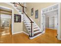 Spacious foyer featuring hardwood floors and staircase with white spindles and stained wood railing at 104 San Sophia Dr, Chapel Hill, NC 27514
