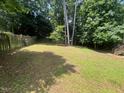 Well-maintained backyard with lush green grass and a wooden fence for privacy at 109 Hidden Farm Ln, Holly Springs, NC 27540