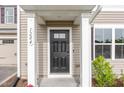 Close-up of a black front door with white trim, flanked by columns and house number 1204 at 1204 Bridgewater Dr, Durham, NC 27704
