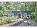 Charming two-story home featuring blue siding, a brick foundation, and a lovely deck nestled among lush trees at 19 Learned Pl, Durham, NC 27705