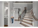 Spacious foyer featuring marble flooring, staircase with decorative iron railing, and access to a powder room at 204 Franconia Way, Apex, NC 27502
