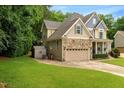Beautiful home exterior with a stone facade, attached garage, and lush green lawn at 218 Kinvara Ct, Wake Forest, NC 27587
