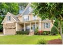 Inviting home exterior featuring a covered porch, stone accents, and a well-maintained yard at 218 Kinvara Ct, Wake Forest, NC 27587