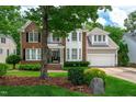 Traditional two-story home featuring brick and siding exterior, mature landscaping, and attached garage at 221 Roebling Ln, Cary, NC 27513