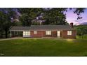 Brick home with a covered parking area, set against a backdrop of a vibrant sunset at 2291 Gentry Ridge Rd, Roxboro, NC 27574