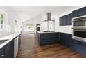Open concept kitchen with stainless appliances, white countertops and island, with dark blue cabinets at 2318 E Main St, Durham, NC 27703