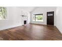 Bright living room featuring a decorative fireplace, large windows, and hardwood floors at 2318 E Main St, Durham, NC 27703