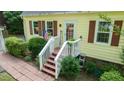 Quaint front porch featuring an American flag, brick walkway, and well-maintained landscaping at 2410 Wade Hampton Rd, Hillsborough, NC 27278