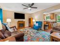Cozy living room featuring a fireplace, hardwood floors, a ceiling fan, and a colorful patterned rug at 2410 Wade Hampton Rd, Hillsborough, NC 27278