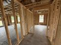 Unfinished hallway showcasing 2x4 stud framing and open doorway at 29 Chloe Ct, Selma, NC 27576
