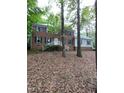 Inviting two-story brick home featuring a classic design, white railings, and nestled among mature trees at 3300 Barnsley Ln, Raleigh, NC 27604