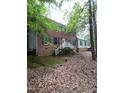 Traditional brick home with white accents, a welcoming porch, and surrounded by mature trees for privacy at 3300 Barnsley Ln, Raleigh, NC 27604