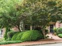 A well-maintained brick house boasts lush green landscaping, mature trees, and a welcoming entrance at 3339 Ridgecrest Ct, Raleigh, NC 27607