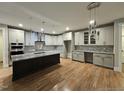 Spacious kitchen boasts white cabinets, granite countertops, stainless steel appliances, an island with dark wood and breakfast bar at 35 Big Bear Dr, Pittsboro, NC 27312
