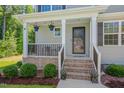 Inviting front porch with brick steps, hanging plants, and cozy seating area at 40 Otter Ct, Youngsville, NC 27596