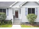 Inviting front entrance with white steps and trim, complemented by manicured greenery and classic shutters at 404 Denton St, Durham, NC 27713